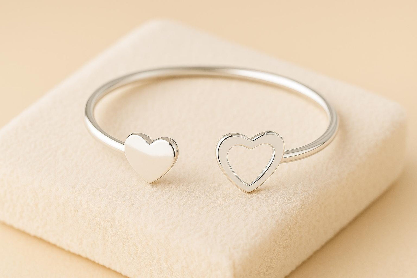 Silver bracelet with heart designs on a beige surface