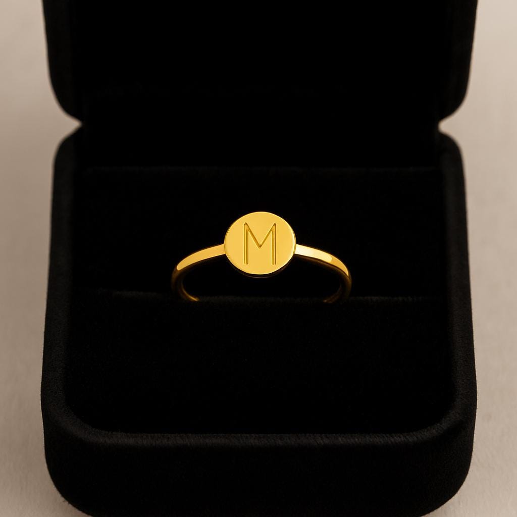Gold ring with a monogram in a black jewelry box