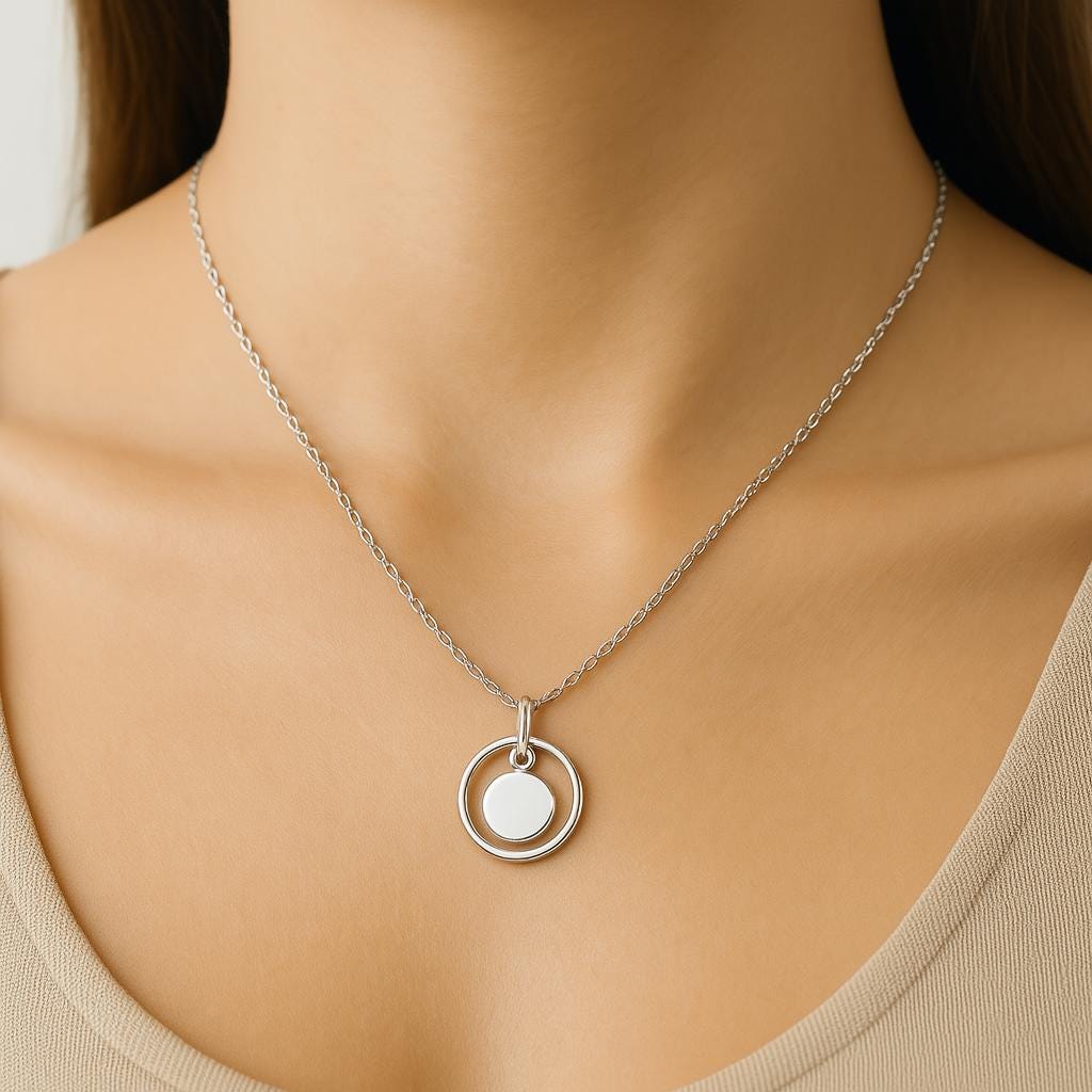 Silver necklace with a pendant on a model wearing a beige top