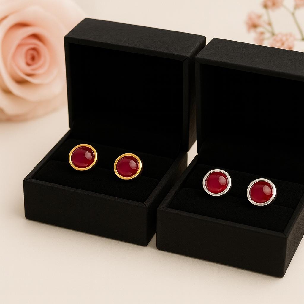 Red ruby gemstone cufflinks in black display cases with floral background
