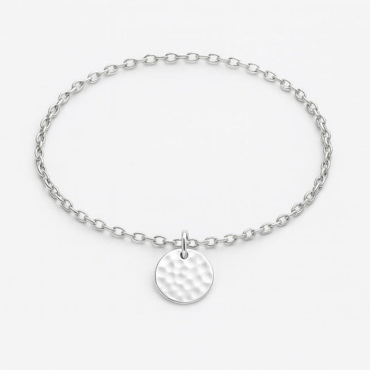 Silver bracelet with a round, textured charm on a light gray background