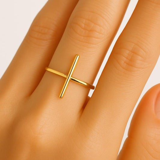 Gold ring on a person's finger with a plain background