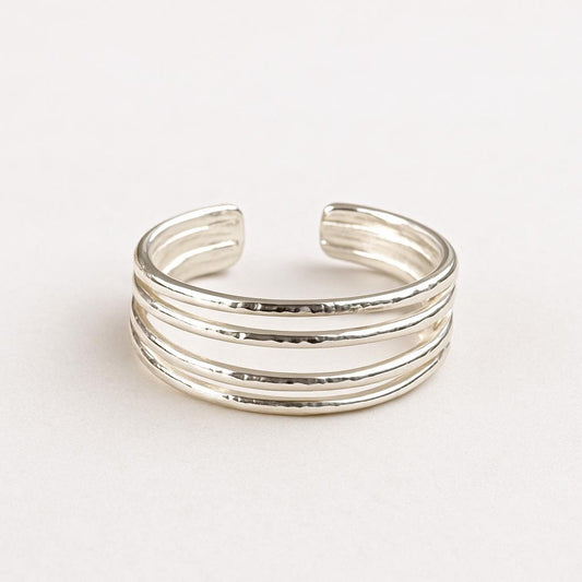 Silver 4 band toe ring with multiple bands on a light gray background