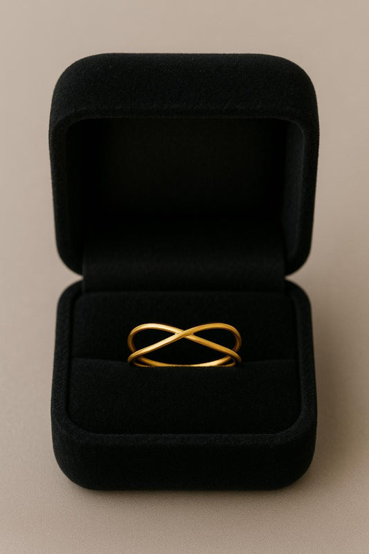 Gold ring with a unique design in a black jewelry box on a beige background