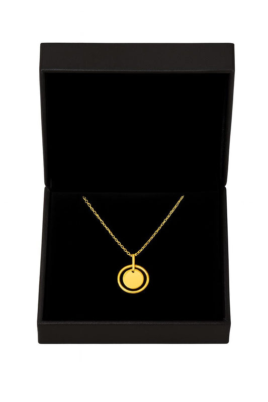 Gold necklace with a pendant in a black jewelry box on a white background