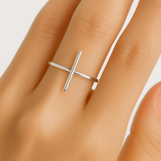 Silver ring on a person's finger against a neutral background