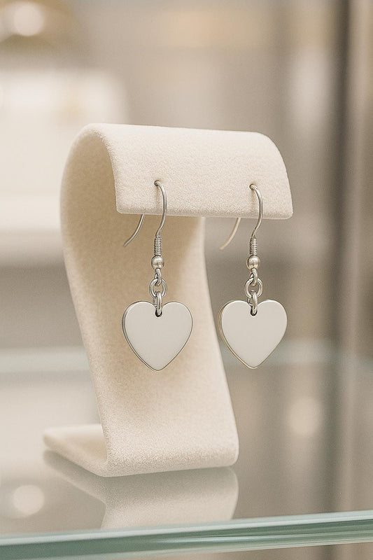 Heart-shaped earrings on a white stand with a blurred background