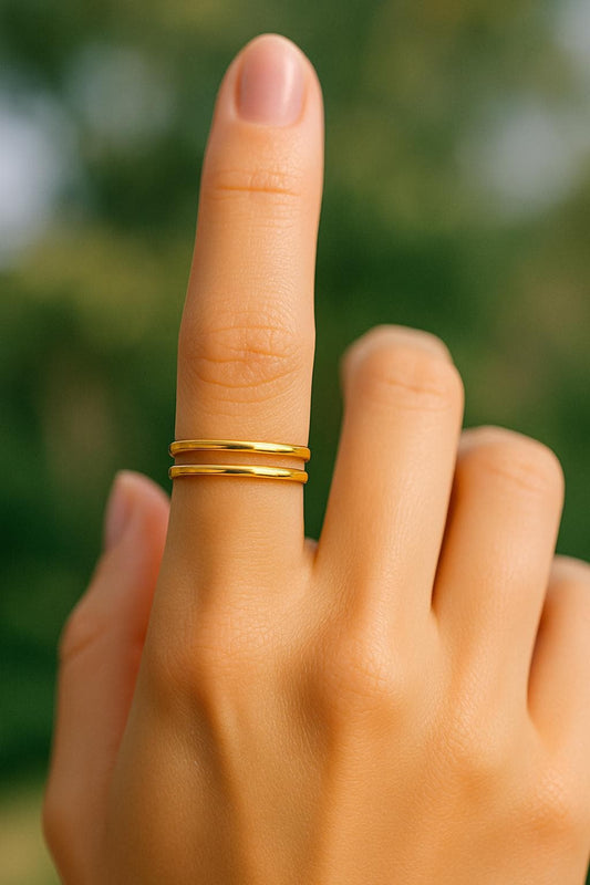 Hand with a gold ring on a blurred green background
