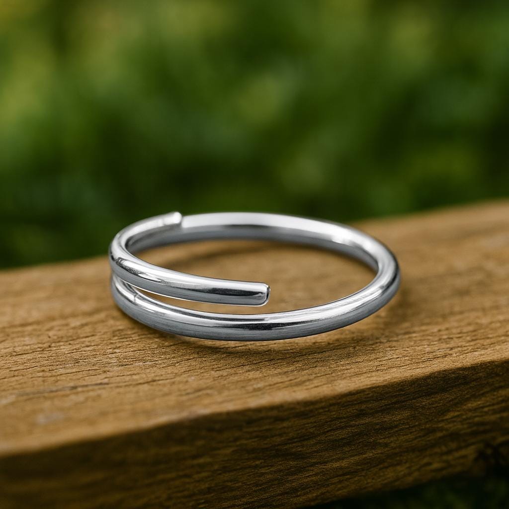 Silver ring on a wooden surface with a blurred green background