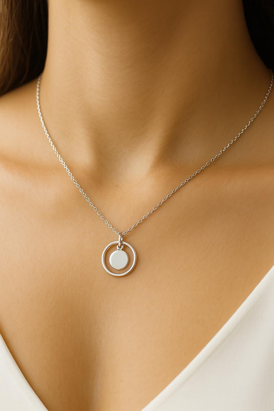 Necklace with a pendant on a person wearing a white top