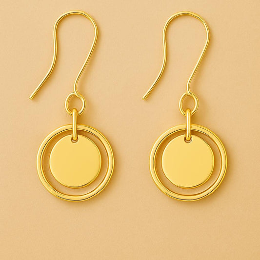 Gold earrings with circular design on a beige background