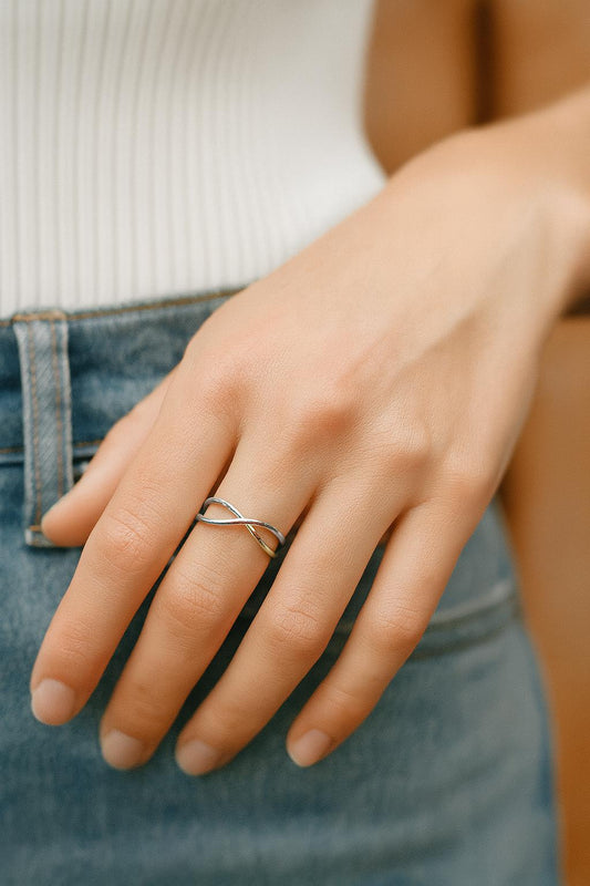 Hand wearing a gold ring with a blurred background