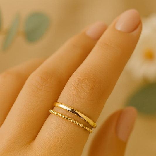 Gold ring on a finger with a blurred floral background