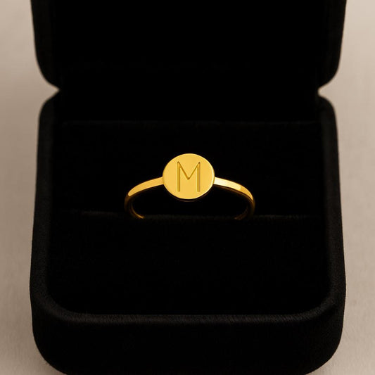 Gold ring with a monogram in a black jewelry box