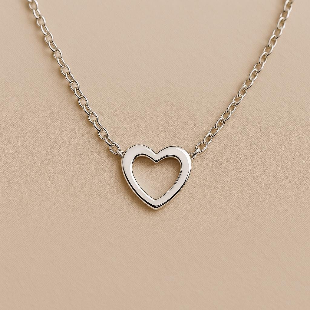 Silver heart-shaped necklace on a beige background