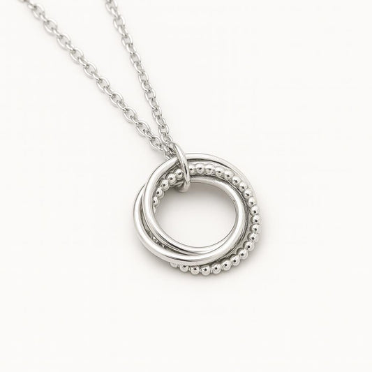 interlocking rings necklace, sterling silver pendant necklace, silver circle necklace, unity necklace, minimalist silver necklace, triple ring pendant, hammered silver necklace, beaded silver pendant, modern geometric necklace, handcrafted silver jewelry, dainty silver necklace, layering silver necklace, sterling silver chain necklace, artisan made jewelry, everyday silver jewelry, simple elegant necklace, gift for her jewelry, bridesmaid silver necklace, anniversary necklace, St Clair Fine Jewelry necklace