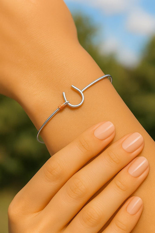 Silver bracelet on a wrist with a blurred natural background