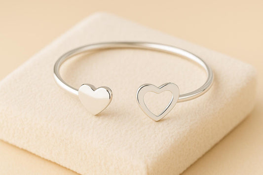 Silver bracelet with heart designs on a beige surface